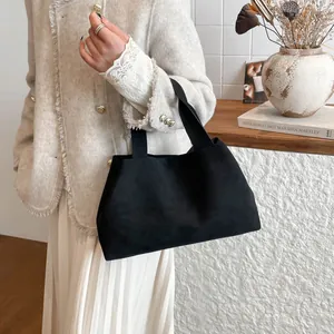 Minimalist black matte felt tote bag with wide straps shown in a lifestyle setting
