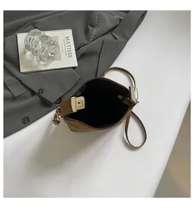 Top-down view of a vintage coffee suede shoulder bag featuring a gold rectangular lock