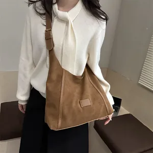 Minimalist caramel brown suede hobo bag with adjustable strap and vintage chic style
