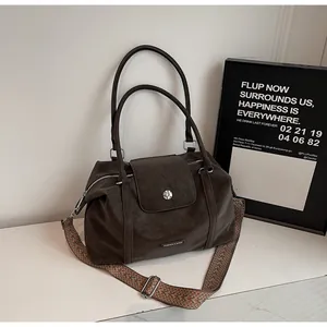 Detail of dark coffee vintage tote with textured wide woven strap and metal logo