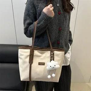 Retro canvas tote bag with leather trim and cloud pendant, shown on model shoulder
