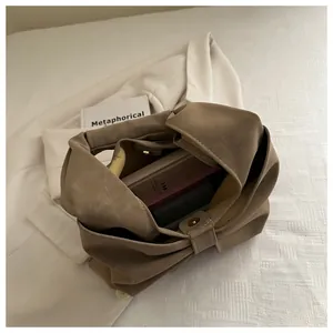 Internal view of khaki soft leather handbag with magnetic buckle and knot handle