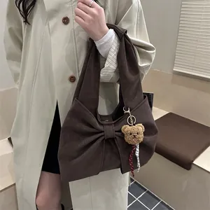 Brown suede-texture handbag featuring large bow detail and cute teddy bear charm