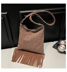 Détail du sac à bandoulière marron foncé en simili daim avec de longues franges