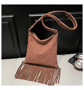 Gros plan du sac bandoulière en daim fauve avec de longues franges en cuir souple
