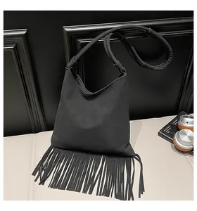 Gros plan détaillé d'un sac à bandoulière noir à franges avec une texture mate élégante