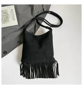 Détail du sac bandoulière noir avec de longues franges et une bandoulière rembourrée
