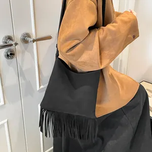 Sac à bandoulière noir de style ethnique avec de longues franges et un design minimaliste