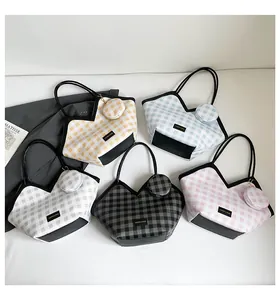 Flat lay of plaid bucket bags in five colors with matching mini pouches and V-shaped opening