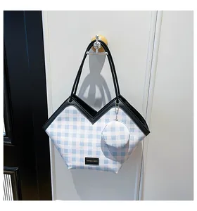 Detail of blue plaid tote bag with mini round pouch and black V-shaped leather trim