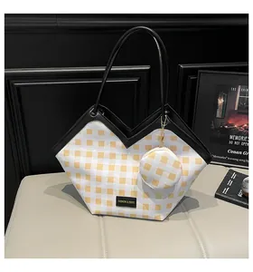 Close-up of a yellow and white checkered tote bag featuring a leather trim and mini purse
