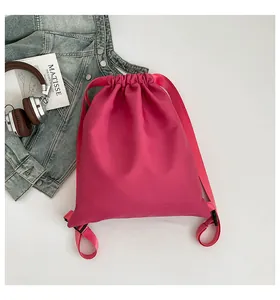 Detailansicht des pinkfarbenen Tunnelzug-Rucksacks mit Büchern und Kopfhörern gestylt
