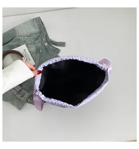 Detailansicht der geräumigen schwarzen Innenseite und des Kordelzugs dieser lila Beuteltasche