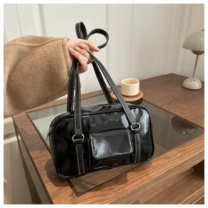 Detail of vintage black patent leather bag with white contrast stitching and silver hardware