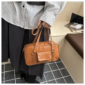 Close-up of retro brown PU leather handbag with white contrast stitching and front pocket