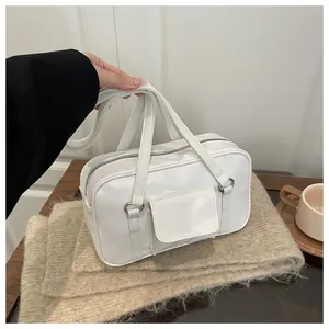 Detail of white glossy PU leather handbag featuring a front pocket and silver hardware
