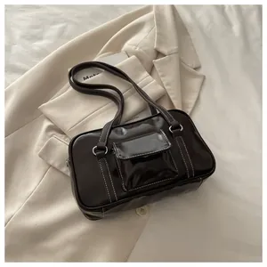 Close-up of a vintage dark brown shoulder bag featuring contrast white stitching and flap pocket