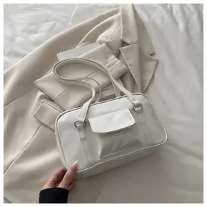 Detail showing white rectangular faux leather handbag with front flap pocket and silver rings