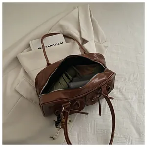 Macro view of brown bowling bag interior showing capacity for umbrella and notebook