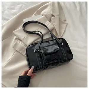 Detail of black faux leather bag with white contrast stitching and silver hardware