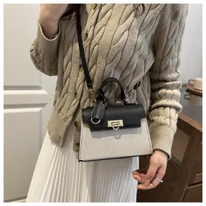 Detailed shot of canvas and black leather crossbody bag with gold-tone twist lock