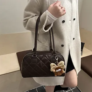 Quilted dark brown bowling bag with plush monster charm and elegant long handles