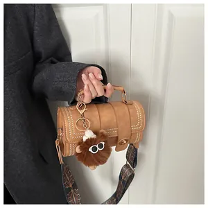 Close-up of a vintage brown barrel handbag with metallic studs and ethnic pattern strap