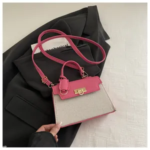 Detail showing pink leather contrast texture and gold metal twist lock on the handbag
