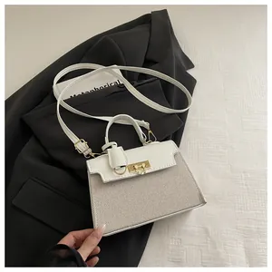 Close-up of contrast stitching, woven texture, and gold twist lock on the luxury handbag