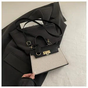 Detail of a contrast leather and woven mini bag with gold hardware on a blazer