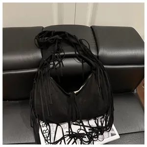 Détail du sac besace noir à franges avec texture daim mate et style bohème chic