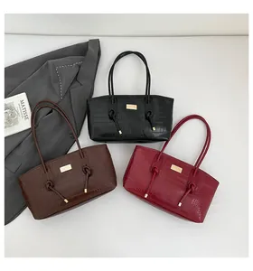 Close-up of crocodile pattern leather tote bags in black, coffee, and burgundy colors