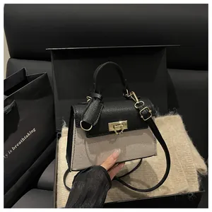 Detail of contrast stitch handbag with textured leather flap and golden twist lock