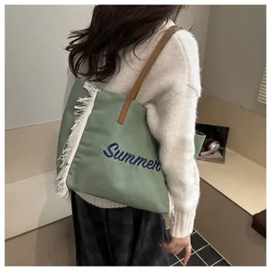 Détail du sac cabas en toile verte avec franges blanches et broderie Summer sur le côté
