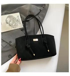 Detail of black quilted tote bag featuring gold metal hardware and knotted handle texture
