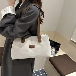 Grand sac cabas beige en toile avec anses en cuir marron et surpiqûres verticales chic