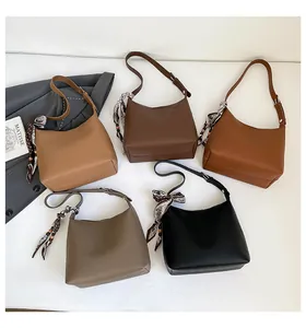Flat lay of litchi texture handbags in five colors featuring decorative silk scarves