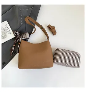 Detailed view of a brown pebbled leather hobo bag with floral silk scarf and striped pouch
