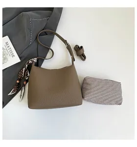 Detail view of coffee leather handbag set with polka dot scarf and striped inner pouch