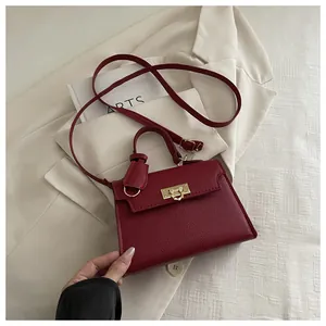 Detail of dark red lychee grain leather bag with elegant gold square metal buckle
