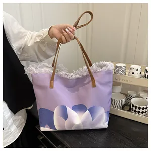 Detalle del bolso tote morado con bordes deshilachados y estampado abstracto de tulipán