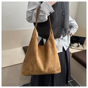 Close-up of retro brown suede hobo bag shown with a model for urban commuter style