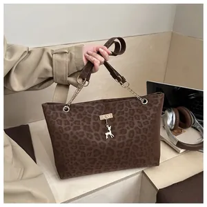 Dettaglio della borsa tote leopardata con catena dorata e ciondolo a cervo