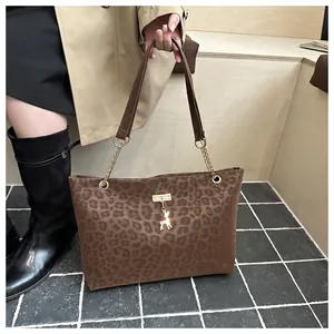 Dettaglio della borsa tote leopardata con ciondolo cervo dorato e tracolla a catena
