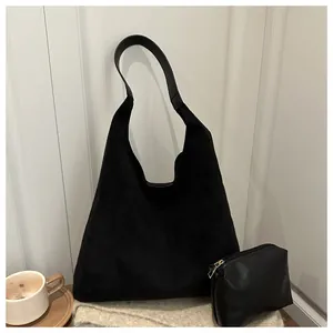 Detailed view of black suede hobo shoulder bag with a matching small zip pouch