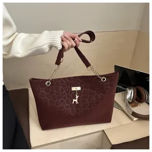Dettaglio borsa shopper leopardata con ciondolo a cervo dorato e tracolla a catena
