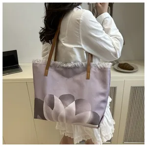 Detalle del bolso tote floral con degradado púrpura y correas de cuero marrón
