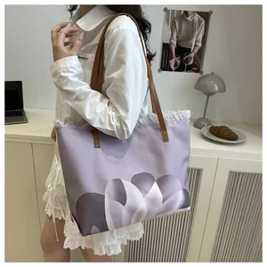 Detalle del bolso tote lila con estampado de tulipanes, flecos y correas marrones