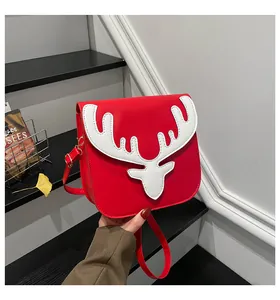 Détail du sac bandoulière en cuir PU rouge avec un design de bois de renne blanc