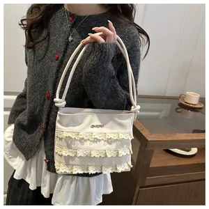 Detailed view of cream lace ruffles and metal logo on women's vintage square handbag